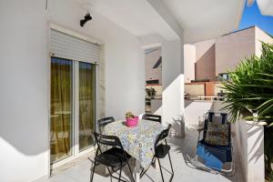 patio con mesa y sillas en el balcón en Casa Martina en Giugliano in Campania