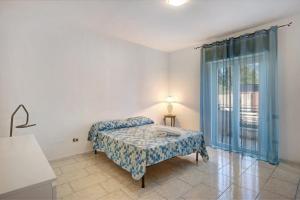 1 dormitorio con 1 cama, 1 silla y 1 ventana en Casa Martina en Giugliano in Campania