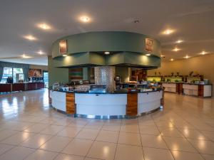 a restaurant with a counter in the middle of a building at Bodrum Beach Resort in Gümbet