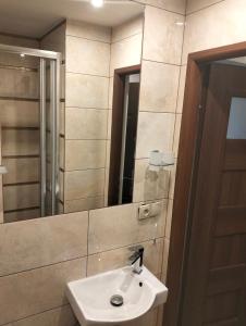 a bathroom with a sink and a mirror at Komfortowy pokój gościnny 300 m od morza dzielnica uzdrowisk in Kołobrzeg