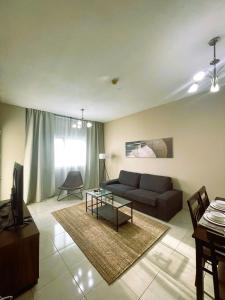 a living room with a couch and a table at Marbella Holiday Homes - Al Nahda 2BHK in Dubai