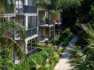 an apartment building with balconies and palm trees at Bodrum Beach Resort in Gümbet