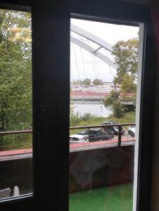 a window with a view of a boat in the water at Komfortowy pokój gościnny 300 m od morza dzielnica uzdrowisk in Kołobrzeg