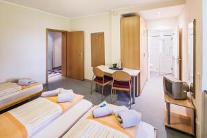 a room with two beds and a table and a television at Schacht III/ABZ in Gelsenkirchen