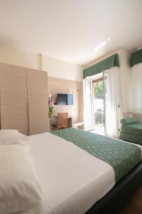 a bedroom with a large white bed and a balcony at Hotel Esperia in Genoa