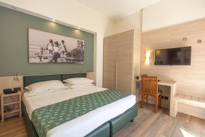 a hotel room with a bed and a tv at Hotel Esperia in Genoa