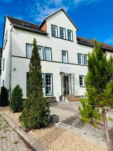 una casa blanca con árboles delante de ella en Ferienwohnung ,,Doina", en Gehlberg