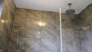 a shower with a glass door in a bathroom at Summerhill, Wrexham - Key Worker friendly in Wrexham +7 photos