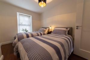 2 camas en una habitación pequeña con ventana en 4 Connaught Street Birr, en Birr
