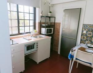 a small kitchen with a sink and a refrigerator at Casa em Palmela - Setúbal in Palmela