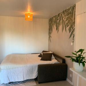 ein Schlafzimmer mit einem Bett und einer Topfpflanze in der Unterkunft Superbe studio tendance et zen proche de Lyon in Couzon-au-Mont-dʼOr