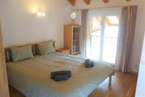 a bedroom with a large bed with a large window at Casa Amélie in Caslano