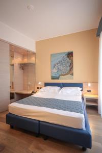 熱那亞的住宿－伊斯佩里亞酒店，卧室配有一张大床,墙上挂有绘画作品