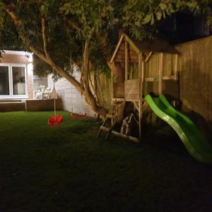 a playground with a slide and a play house at House on Costal Village in Peacehaven