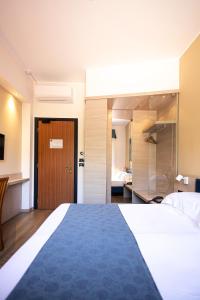 a bedroom with a large bed and a bathroom at Hotel Esperia in Genoa