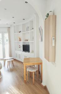 - un salon blanc avec une table en bois et un bureau dans l'établissement Apartamento Hermosilla, à Malaga