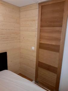 - une chambre avec un placard en bois et un lit dans l'établissement Appartement pied des pistes Puy Saint Vincent (05), à Puy-Saint-Vincent