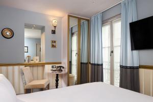 une chambre d'hôtel avec un lit et une fenêtre dans l'établissement Les Plumes Hotel, à Paris