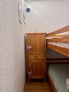 um quarto com um beliche e um armário de madeira em Appartement pied des pistes Puy Saint Vincent (05) em Puy-Saint-Vincent
