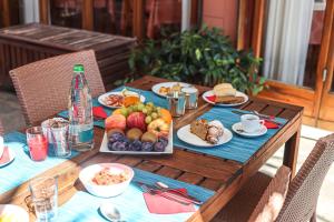 einem Holztisch mit Teller mit Lebensmitteln darauf in der Unterkunft Hotel Esperia in Genua