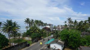 una calle en una ciudad con palmeras y el océano en Surf view resort, en Ahangama