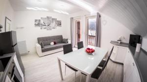 een witte woonkamer met een tafel en een bank bij Appartamento Stella in Andalo