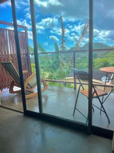 Habitación con balcón con sillas y mesa. en Flats Baia dos Porcos, en Fernando de Noronha