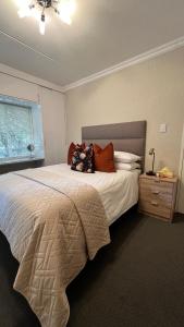 a bedroom with a large bed with pillows on it at Tanelsa Apartment on West in Johannesburg