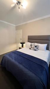 1 dormitorio con 1 cama grande con manta azul en Tanelsa Apartment on West en Johannesburgo