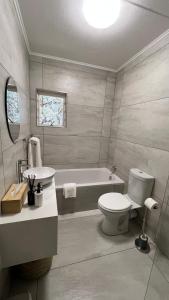 a bathroom with a tub and a toilet and a sink at Tanelsa Apartment on West in Johannesburg