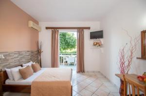 a room with a bed and a table with a television at Theodora Studios Best Location In Laganas Next To The Party Area in Laganas