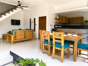 a dining room and kitchen with a wooden table and chairs at Villa Solas Legian in Legian