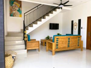 a living room with a staircase with blue furniture at Villa Solas Legian in Legian