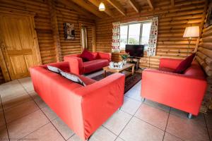 ein Wohnzimmer mit roten Möbeln in einem Blockhaus in der Unterkunft Mallard Lodge in Selby