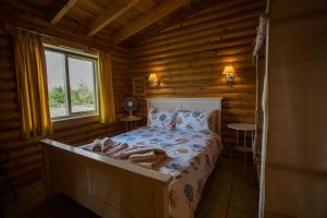 ein Schlafzimmer mit einem Bett in einem Blockhaus in der Unterkunft Mallard Lodge in Selby