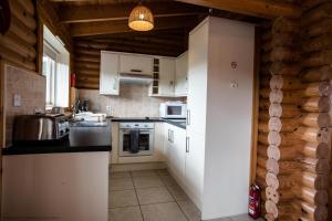 a kitchen with white cabinets and a counter top at Mallard Lodge in Selby +1 photo