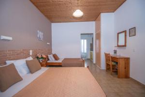 um quarto com uma cama, um sofá e uma secretária em Dora Studios em Laganas