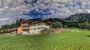 a large house in a field with a green field at Gsolhof in Rettenberg