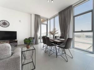 a living room with a dining room table and chairs at StoneTree - Spacious 3 BR in The Pulse C2 in Dubai