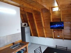 a kitchen with a sink and a tv on a wall at Amancay Cabaña alpina en Valle Fértil in San Agustín de Valle Fértil