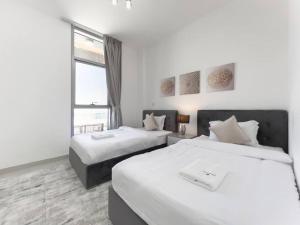 a hotel room with two beds and a window at StoneTree - Spacious 3 BR in The Pulse C2 in Dubai