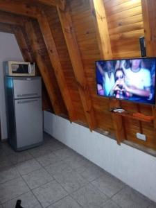 a flat screen tv on a wall in a kitchen at Amancay Cabaña alpina en Valle Fértil in San Agustín de Valle Fértil