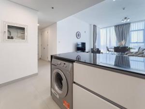 a kitchen and living room with a washing machine at StoneTree - Spacious 3 BR in The Pulse C2 in Dubai