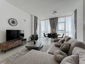 a living room with a couch and a flat screen tv at StoneTree - Spacious 3 BR in The Pulse C2 in Dubai