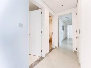 a hallway with white walls and white floors at StoneTree - Spacious 3 BR in The Pulse C2 in Dubai