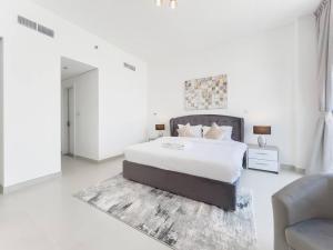 a white bedroom with a large bed and a couch at StoneTree - Spacious 3 BR in The Pulse C2 in Dubai +33 photos