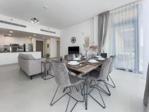 a dining room and living room with a table and chairs at StoneTree - Spacious 3 BR in The Pulse C2 in Dubai