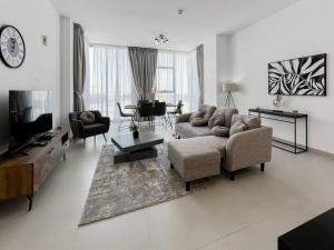 a living room with a couch and a tv at StoneTree - Spacious 3 BR in The Pulse C2 in Dubai