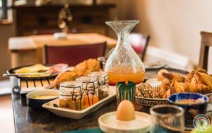 a table topped with plates of food and a vase at Le Nid du Coucou in Cocumont