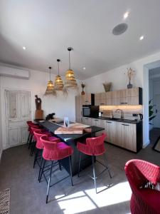 a kitchen with red chairs and a black counter top at Maison de ville Duplex Artienzo in Sarlat-la-Canéda